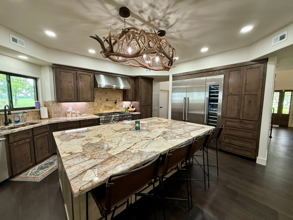 Kitchen with a natural stone island and wood cabinetry